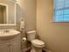 A half bathroom features a sink with a white cabinet, toilet, and window for natural light at 46 Darbys Crossing Ct, Hiram, GA 30141