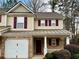 Charming townhome with a brick and vinyl facade, a one-car garage, and covered front porch at 46 Darbys Crossing Ct, Hiram, GA 30141