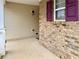 Exterior view of a home's porch with brick accents, beige siding, and maroon shutters at 46 Darbys Crossing Ct, Hiram, GA 30141
