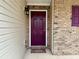 A brick facade and vibrant purple door with welcome mat create an inviting entryway at 46 Darbys Crossing Ct, Hiram, GA 30141