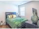 Bedroom with a large window, bed with green comforter, and dark furniture at 8125 Berrywood Se Ct, Covington, GA 30014