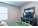 Well-lit bedroom with a large window, bed, dresser, and a dark toned television at 8125 Berrywood Se Ct, Covington, GA 30014