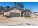 View of a single Gathering home with a two car garage and well-kept yard at 8125 Berrywood Se Ct, Covington, GA 30014