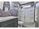 Bathroom featuring a tub-shower combo with a glass door, a modern vanity and a round mirror at 2726 Northgate Nw Way, Acworth, GA 30101
