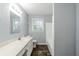 Bathroom showcasing a white vanity, large mirror, window, and combination tub shower at 3368 Windsor Castle Ct, Decatur, GA 30034