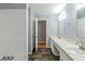 Bathroom featuring double sinks, white cabinets, large mirrors, and a tiled shower at 3368 Windsor Castle Ct, Decatur, GA 30034