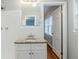 Bathroom featuring granite countertop, white cabinets, mirror, and tiled shower at 3368 Windsor Castle Ct, Decatur, GA 30034