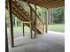 View of the home's under-deck area featuring concrete flooring and exterior stairway at 8033 White Stone Blvd, Douglasville, GA 30135