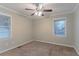 Cozy bedroom featuring carpeted floors, ceiling fan, and natural light from a large window at 2024 Rosewood Rd, Decatur, GA 30032
