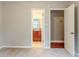 A carpeted room with a door leading to a brightly lit bathroom with a vanity at 3998 Chimney Ridge Dr, Ellenwood, GA 30294