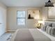 A staged bedroom with carpet, a window and a bed with decoratively arranged pillows at 3998 Chimney Ridge Dr, Ellenwood, GA 30294