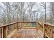 Exterior wooden deck with wooden rails offers a view of the wooded landscape at 3998 Chimney Ridge Dr, Ellenwood, GA 30294