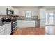Well-lit kitchen with stainless steel appliances, tile backsplash, granite countertops, and tile flooring at 3998 Chimney Ridge Dr, Ellenwood, GA 30294