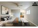 Staged primary bedroom with a ceiling fan, ensuite bath, and a seating bench in front of the bed at 3998 Chimney Ridge Dr, Ellenwood, GA 30294