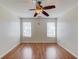 Spacious bedroom featuring two windows, hardwood floors, and a ceiling fan at 1553 Nicole Ridge Ct, Loganville, GA 30052