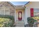 A welcoming front entrance with a red oval glass door, stone accents, and green bushes at 1553 Nicole Ridge Ct, Loganville, GA 30052