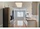 Well-lit kitchen with white cabinets and stainless steel appliances overlooking adjacent dining area at 1553 Nicole Ridge Ct, Loganville, GA 30052