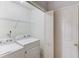 Laundry room with washer and dryer hookups, storage shelf, and door creating an efficient and functional space at 1553 Nicole Ridge Ct, Loganville, GA 30052