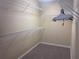 An organized walk-in closet with multiple metal racks, and neutral beige walls at 2610 Gadsen Walk, Duluth, GA 30097