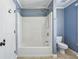 Bathroom featuring a white tub and shower combo and blue accent paint at 8265 Majors Glen Ct, Cumming, GA 30041