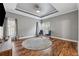Bright bedroom features a tray ceiling, hardwood floors, and large windows at 3207 Haleys Way, Conyers, GA 30013