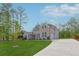 Side view of a brick two-story home featuring an attached two-car garage and a concrete driveway at 8023 White Stone Blvd, Douglasville, GA 30135