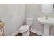 Powder room featuring toilet, wood-look floor, and pedestal sink at 8023 White Stone Blvd, Douglasville, GA 30135