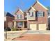 Two-story brick home with a two-car garage and manicured front lawn, exuding classic curb appeal at 2571 Royston Dr, Duluth, GA 30097