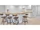 Basement wet bar area featuring five stools, cabinets and a light countertop at 1117 Bridgemill Ave, Canton, GA 30114