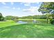 Beautiful view of the golf course pond with fountain and green, rolling hills under a blue sky at 1117 Bridgemill Ave, Canton, GA 30114