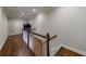 Second story hallway with hardwood floors and wooden railing featuring baby gate at 2368 Saint Davids Nw Sq # 4, Kennesaw, GA 30152