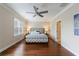 Bright main bedroom featuring hardwood floors, a ceiling fan, and natural light from the windows at 2368 Saint Davids Nw Sq # 4, Kennesaw, GA 30152