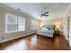 Bright main bedroom featuring hardwood floors, a ceiling fan, and natural light from the windows at 2368 Saint Davids Nw Sq # 4, Kennesaw, GA 30152