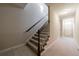Carpeted stairway with wooden railings and a well-lit landing area at 2368 Saint Davids Nw Sq # 4, Kennesaw, GA 30152