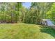 Large backyard featuring a storage shed and mature trees at 3625 Knoll Crest Trl, Buford, GA 30519