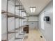 Spacious laundry room with open shelving and tile floors at 3625 Knoll Crest Trl, Buford, GA 30519