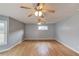 Empty living room with wood floors, multiple windows, and ceiling fans at 3625 Knoll Crest Trl, Buford, GA 30519