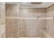 Luxurious tiled shower with rainfall showerhead, built-in niche, and comfortable bench seating at 3625 Knoll Crest Trl, Buford, GA 30519