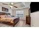 Comfortable main bedroom featuring a tray ceiling, ceiling fan, and a coordinating color palette at 2327 Maple Ave, Morrow, GA 30260