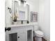 Modern half bathroom with a sleek vanity, framed mirror, and elegant decorative touches at 704 Carriage Ct, Lawrenceville, GA 30044