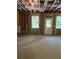 Unfinished basement with a door, studs, concrete floor, and natural light at 8013 White Stone Blvd, Douglasville, GA 30135