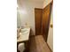 Bathroom featuring sink with wooden cabinets, linoleum flooring, decorative wallpaper, and two access doors at 9033 Greystone Rd, Jonesboro, GA 30238