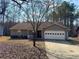 Charming single-story home with a two-car garage and a cozy front porch, nestled among trees at 9033 Greystone Rd, Jonesboro, GA 30238