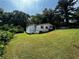 Exterior view of a white house with a green lawn, trees, and a car in the driveway at 2134 Nw Abner Nw Pl, Atlanta, GA 30318