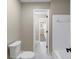 Bright bathroom featuring a toilet, a shower with a tiled wall and an open doorway to the rest of the house at 3017 Lana Ln, Marietta, GA 30066