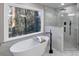 Beautiful bathroom featuring a soaking tub with nature views and a glass-enclosed shower with modern fixtures at 3017 Lana Ln, Marietta, GA 30066