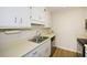 Kitchen showcasing light countertops, wood-look flooring, and stainless steel sink at 475 Mount Vernon Ne Hwy # A-102, Sandy Springs, GA 30328