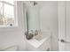 Bright, minimalist powder room with white vanity, modern faucet, and natural light at 603 Old Peachtree Ne Rd, Lawrenceville, GA 30043