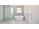 Bright bathroom featuring a glass shower with marble tile and a modern soaking tub by the window at 603 Old Peachtree Ne Rd, Lawrenceville, GA 30043
