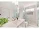 Bright bathroom featuring a large shower with glass door and white marble tile, and a white vanity with stone countertop at 603 Old Peachtree Ne Rd, Lawrenceville, GA 30043